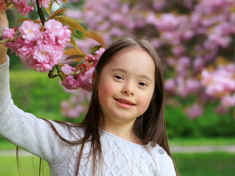 Young girl with Down Syndrome outside in the park